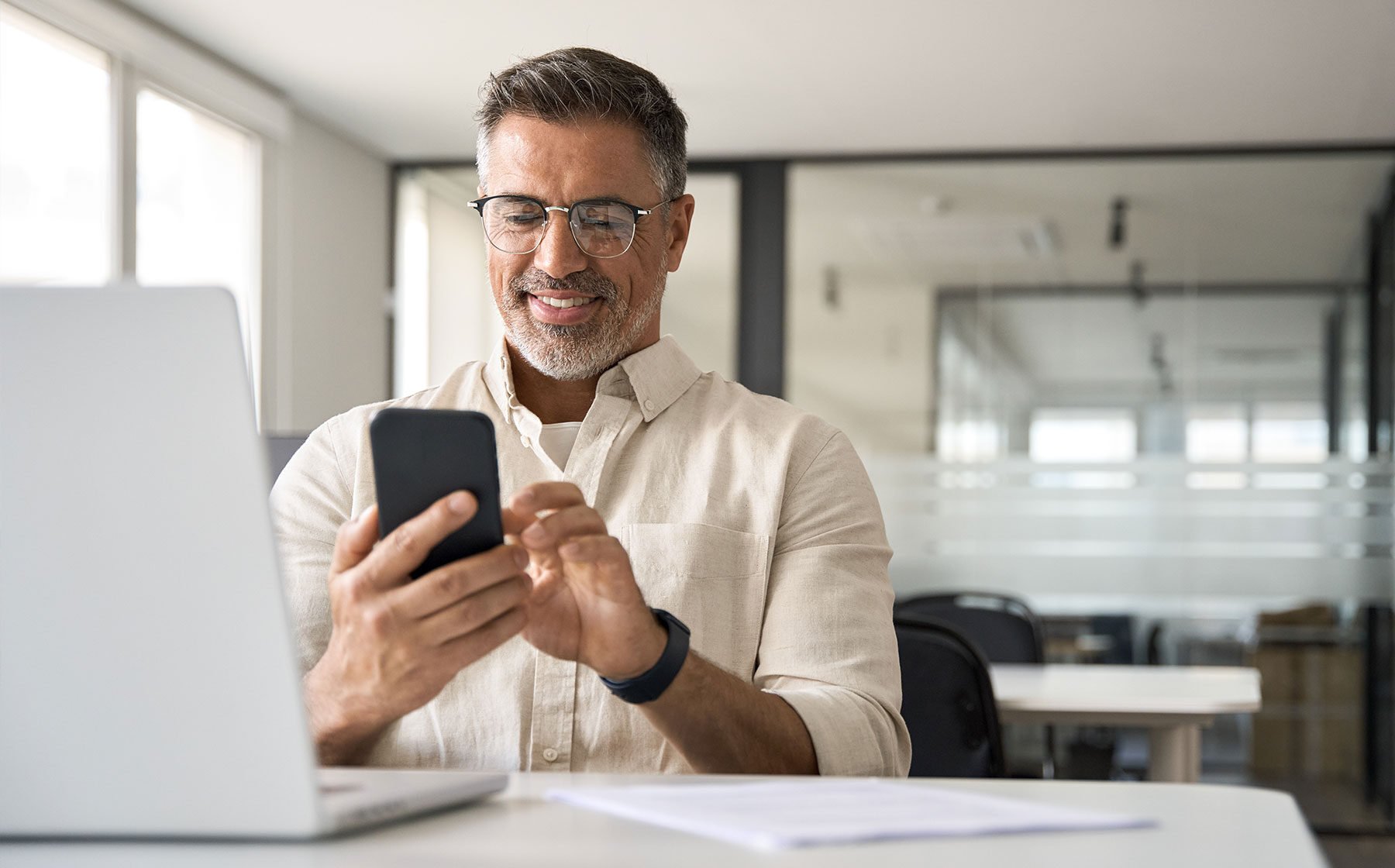 Real estate investor smiling while looking at phone