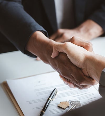 Agent and customer shake hands after successfully signing the contract.