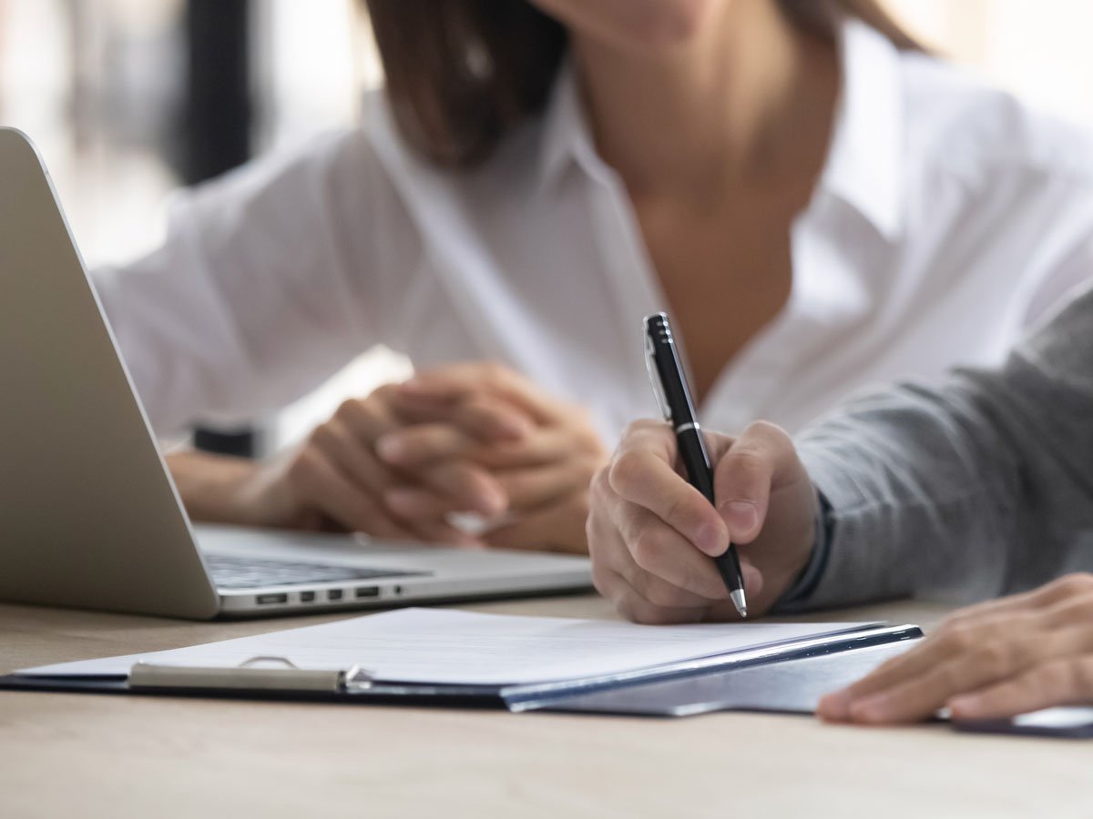 two people signing papers