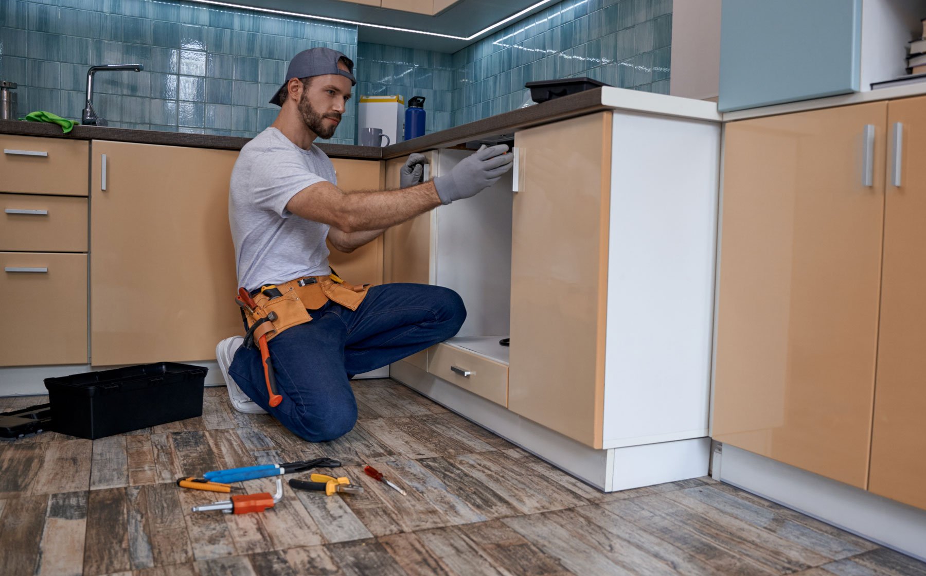 man adding new flooring and cabinets to the kitchen