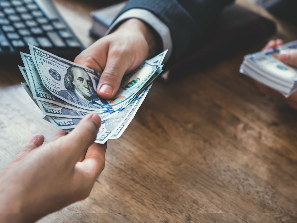 Businessman giving money to another man