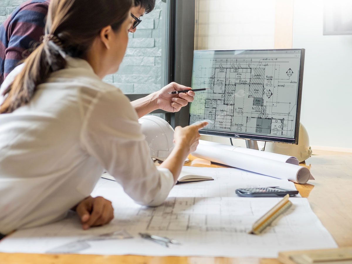 looking over building plans on desktop computer