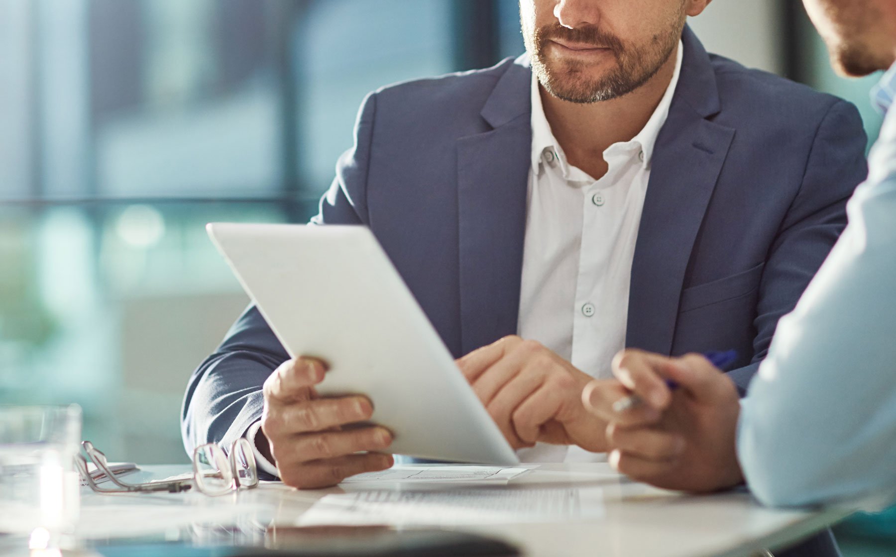 Two people looking at a tablet discussing loan options