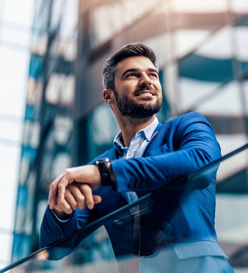 man in blue suit smiles and looks out