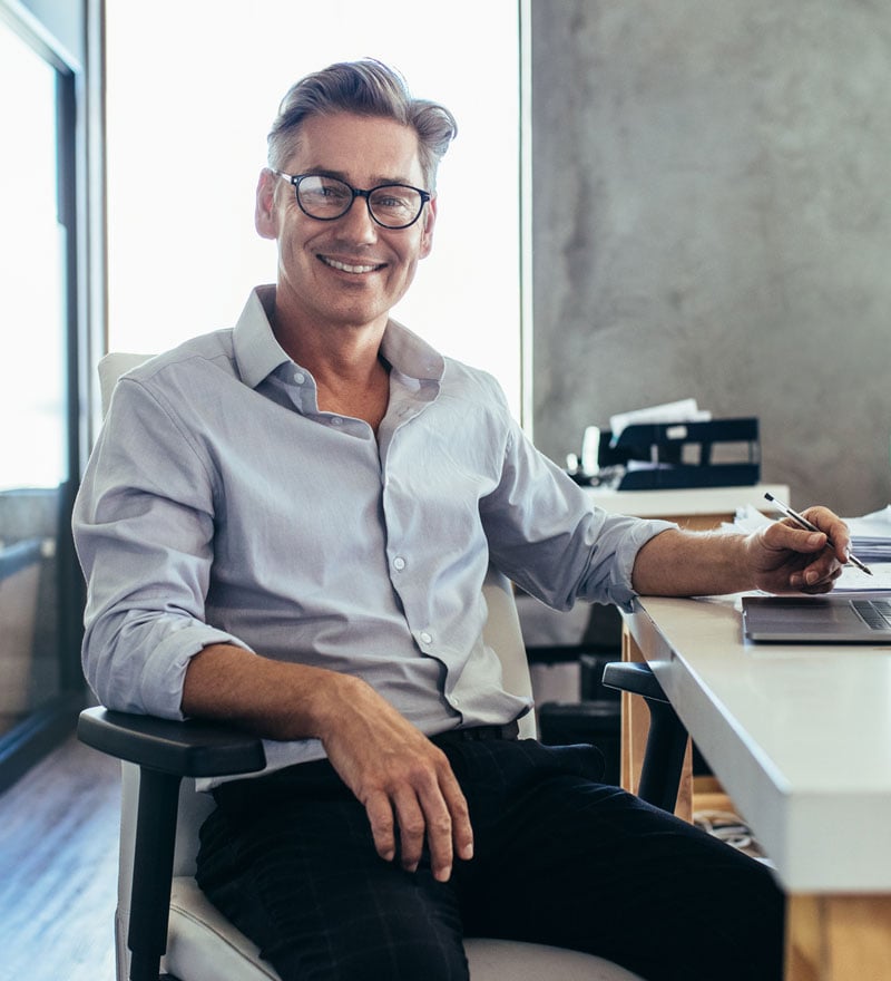 Man smiles at his desk