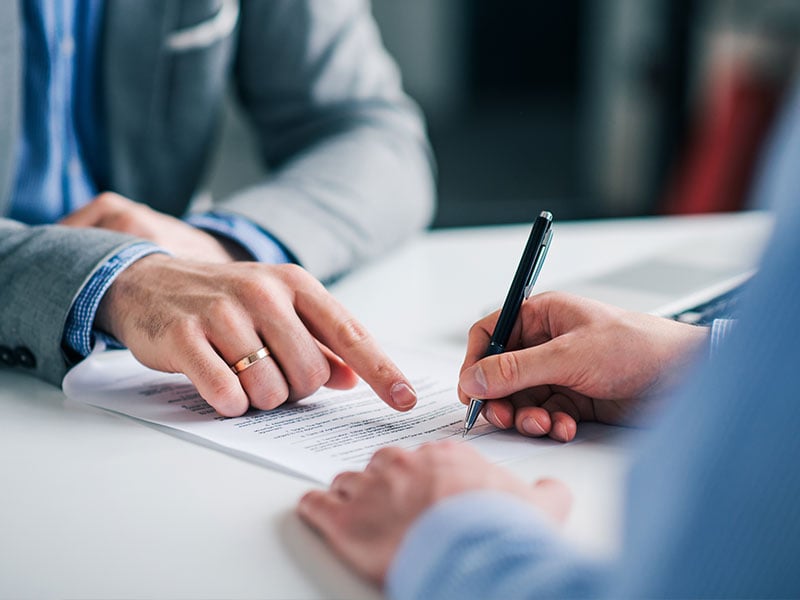 Businessmen hand's pointing where to sign a contract