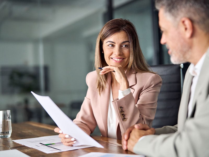Female agent looking at contracts with client